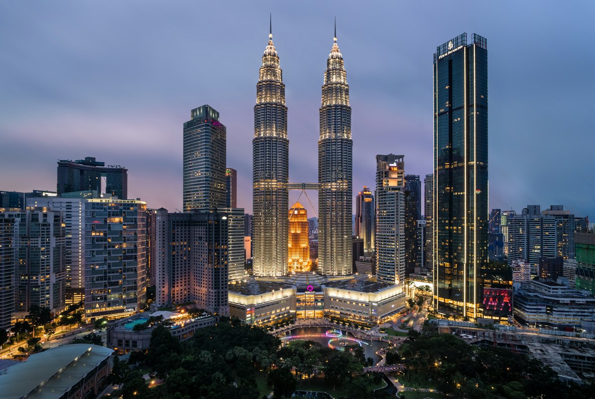 The Petronas Towers above KLCC Park at sunset in Kuala Lumpur.